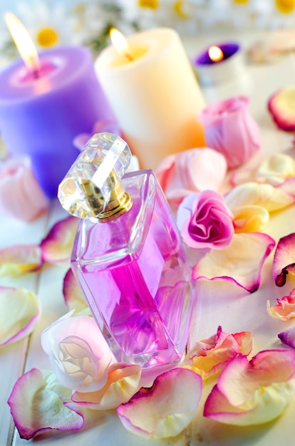 핑크 장미 꽃잎과 향수 병입니다. 패션 메이크업 및 바디 케어 제품.