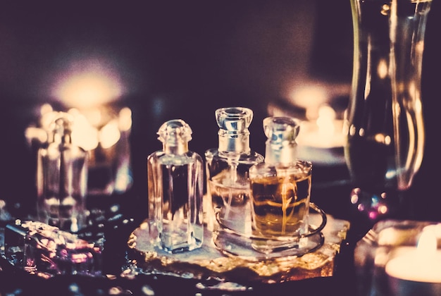写真 香水瓶と夜のヴィンテージ フレグランス アロマの香りの香りのする化粧品と高級ビューティー ブランドのオードトワレ ホリデー ファッション パルファム デザイン