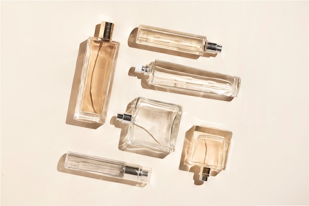 Perfume bottles of beige color. Flatlay still life in the style of minimalism on a cream background, beauty and fashion.