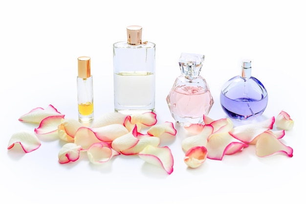 Perfume bottles with flower petals on light background. Perfumery, fragrance collection. Women accessories.