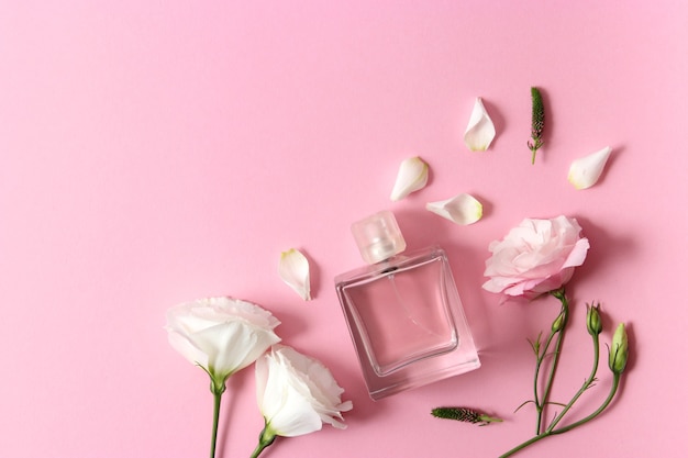 Perfume and flowers on a colored background