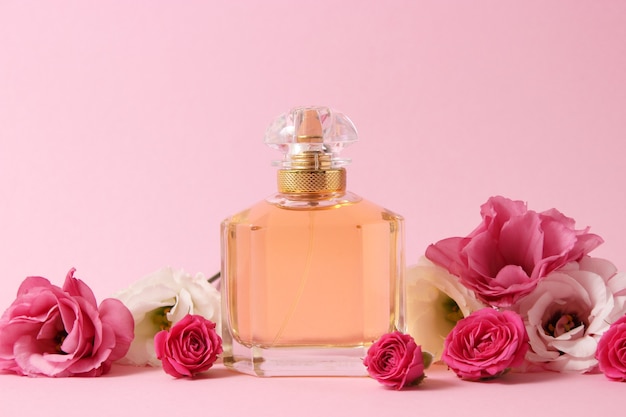 Perfume and flowers on a colored background