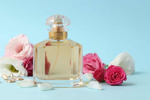 Perfume and flowers on a colored background