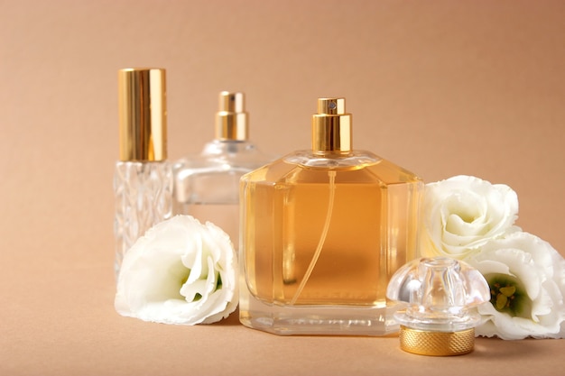 Perfume and flowers on a colored background