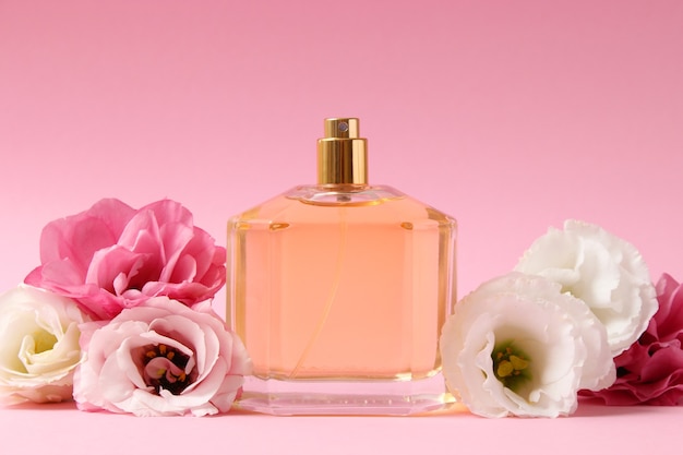 Perfume and flowers on a colored background