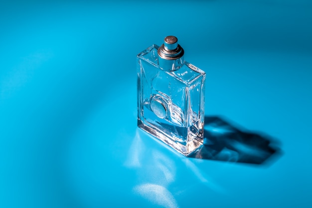 Perfume glass bottle on light blue. Eau de toilette