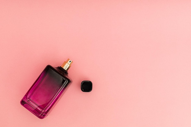 Perfume in a pink bottle on a pink background