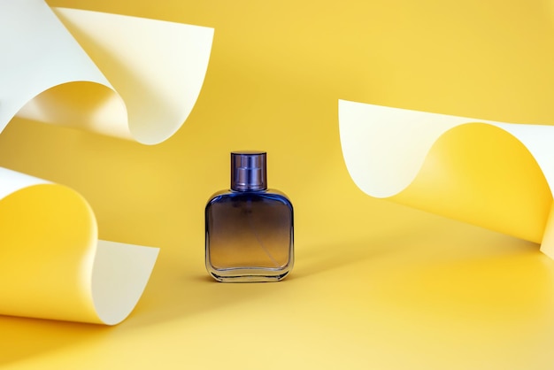 色紙で作られた抽象的な背景の香水スプレー ボトル