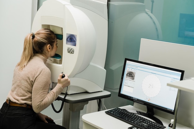 Foto perimetrie-gezichtsveldtest voor het meten van alle gebieden van het gezichtsvermogen, inclusief zij- of perifere visie perimetrie-ogentest voor vroege tekenen van glaucoom van vrouwelijke patiënt van oogheelkundige kliniek