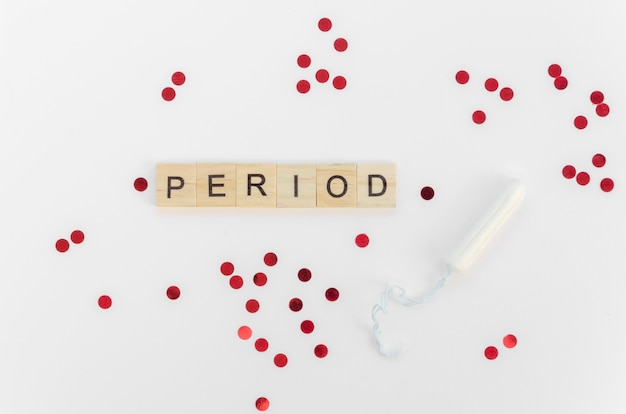 Period word with scrabble letters and red sequins