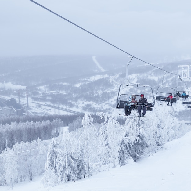 Perm Krai, Rusland - 02 januari 2021: skiërs gebruiken de stoeltjeslift tegen een mistig winterlandschap in de vallei