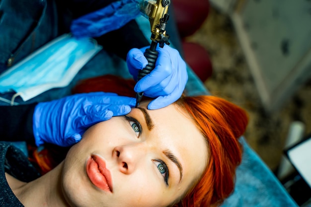 Trucco permanente o tatuaggio sulle sopracciglia al salone di bellezza donna con le sopracciglia colorate trucco semipermanente per le sopracciglia