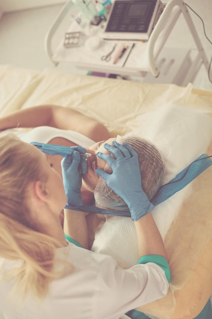 Permanente make-up voor wenkbrauwen Close-up van mooie vrouw met dikke wenkbrauwen in schoonheidssalon