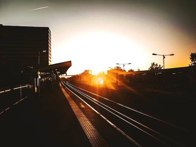 Foto perron van het treinstation bij zonsondergang