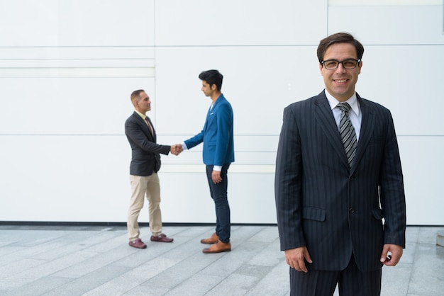 Persian businessmen posing in front of white wall