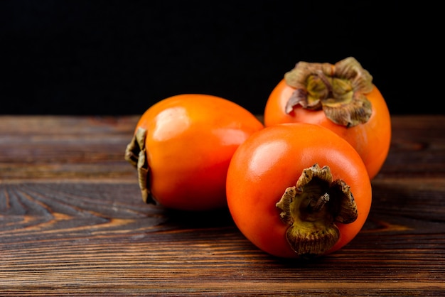 Persimmon on dark wooden 