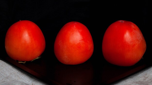 Persimmon drie stukken liggen op een zwarte ondergrond.