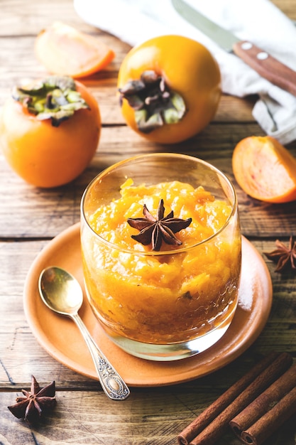 Persimmon fruit smoothie with cinnamon and anise stars, wooden table