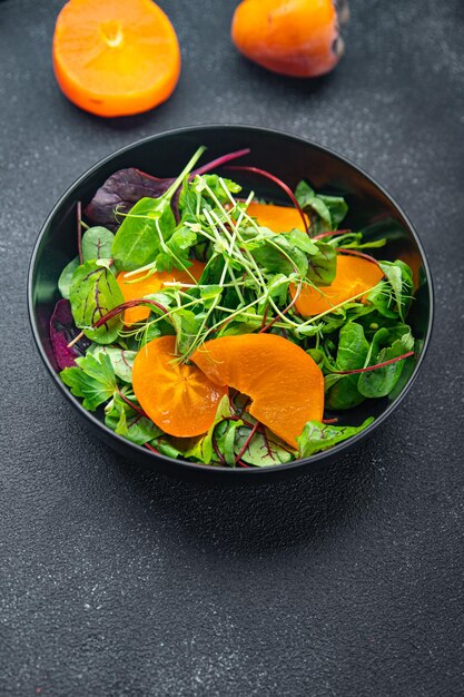 柿のサラダレタスの緑の葉は、テーブルのコピースペースの食べ物に健康的な食事の食べ物のスナックを混ぜます