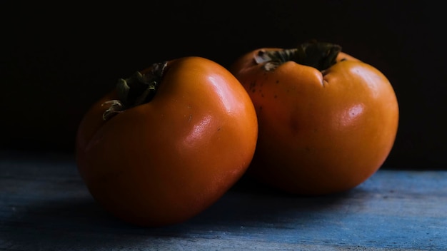 Photo persimmons on dark background. darkfood