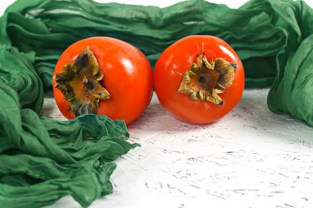 Photo persimmons on a napkin on a white background