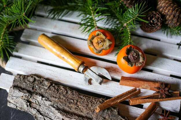 Foto cachi su un vassoio di legno e albero di natale