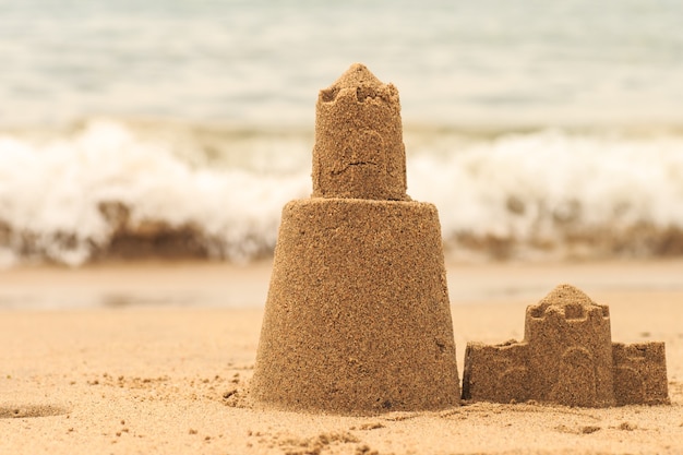 La persistente torre del castello di sabbia si lava via nell'acqua di mare.