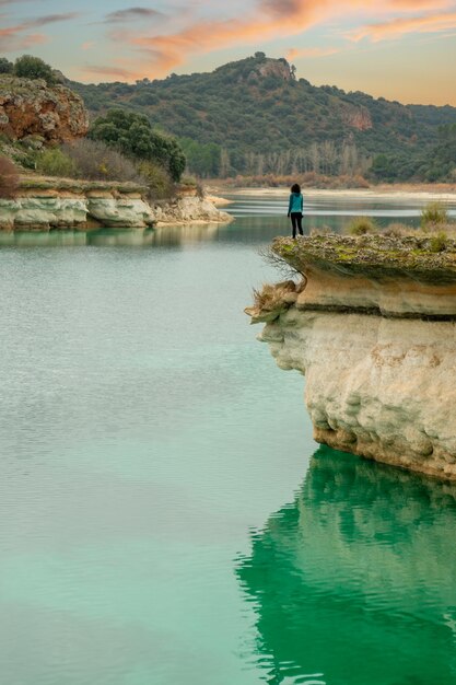 Photo person alone contemplating the lake from a cliff and enjoying nature in the lagoons of ruidera