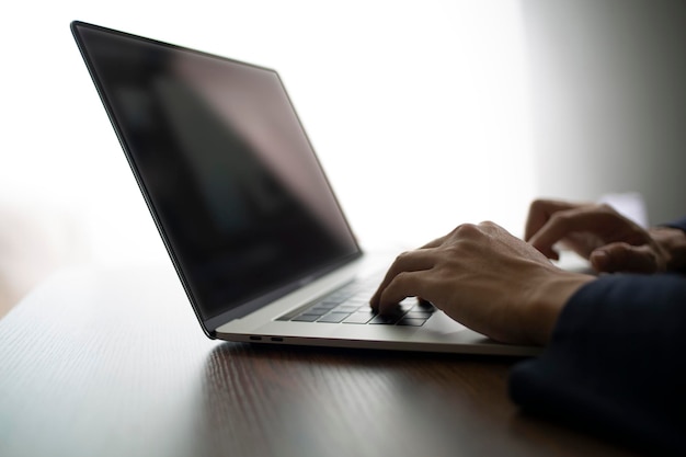 Фото Человек использует ноутбуки, работает или учится онлайн дома бизнесмен использует ноутбук для работы вне офиса