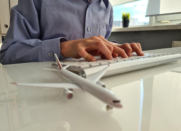 Человек бронирует билет на самолет в Интернете крупным планом