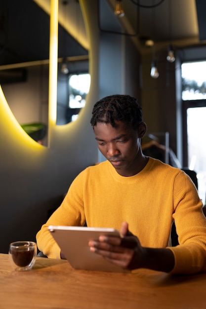 Foto persona in un caffè che legge un libro