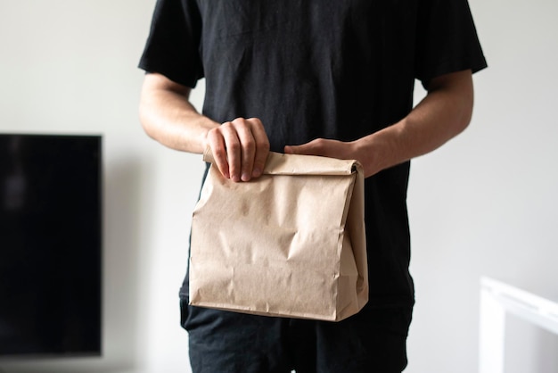 Una persona che trasporta un pacco di carta con cibo consegnato