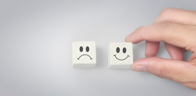 Person choose happy face block over sad face block