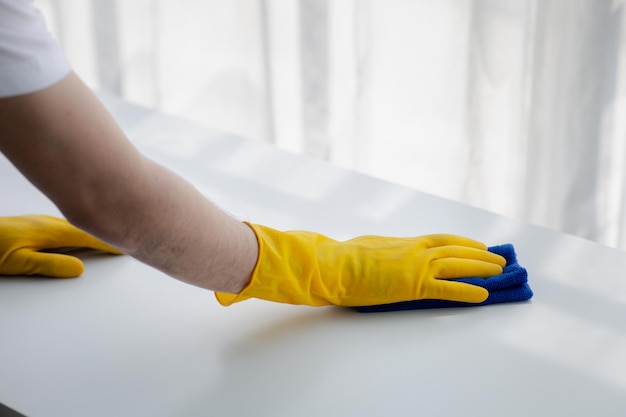 Person cleaning the room cleaning staff is using cloth and spraying disinfectant to wipe the desk in the company office room Cleaning staff Maintaining cleanliness in the organization