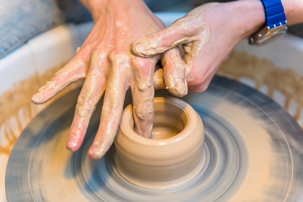 Person creating a clay cup