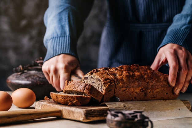 Person cutting cereal bread on board