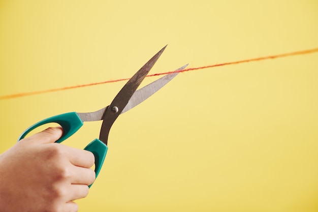 Person cutting red thread