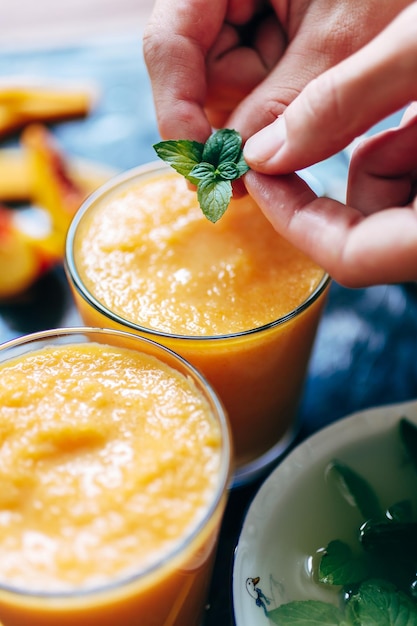 Person decorates orange smoothie