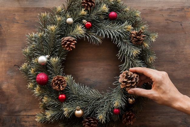 Person decorating Christmas wreath 