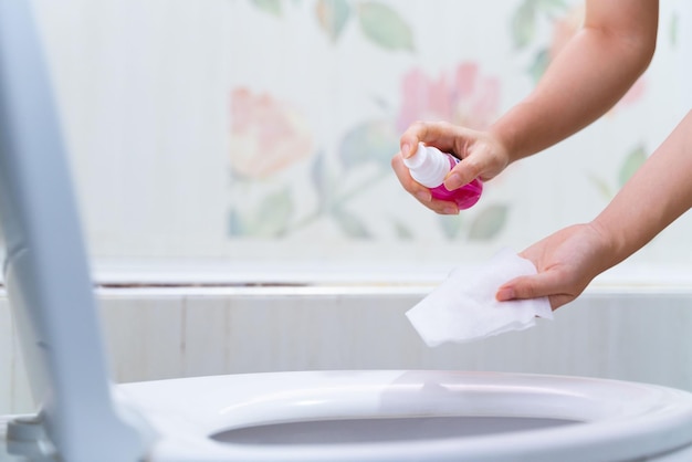 Person disinfecting a toilet seat