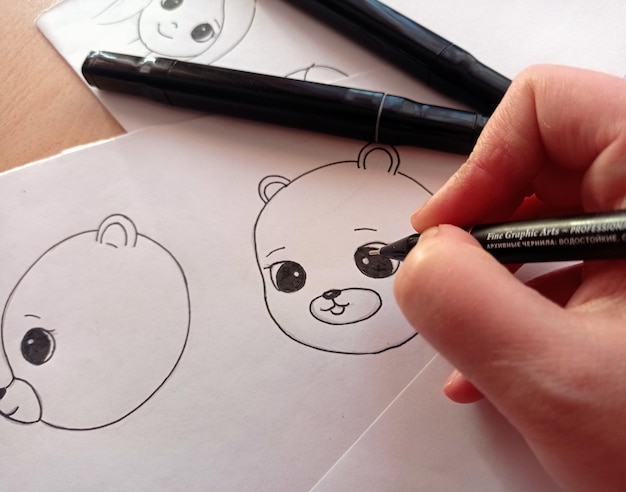 Foto una persona che disegna una faccia con una penna nera.