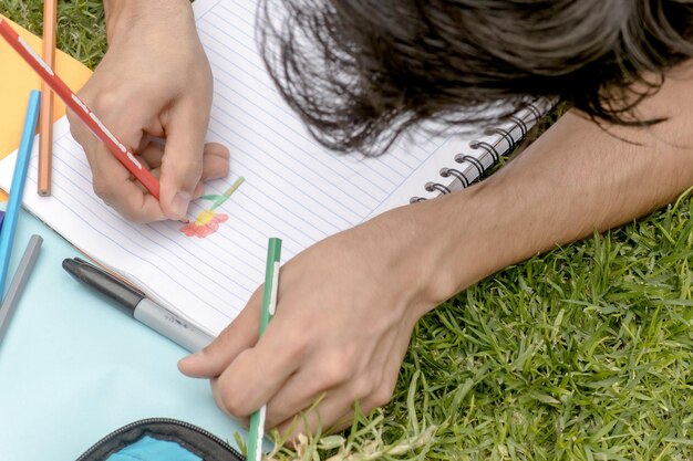 A person drawing a flower in a notebook