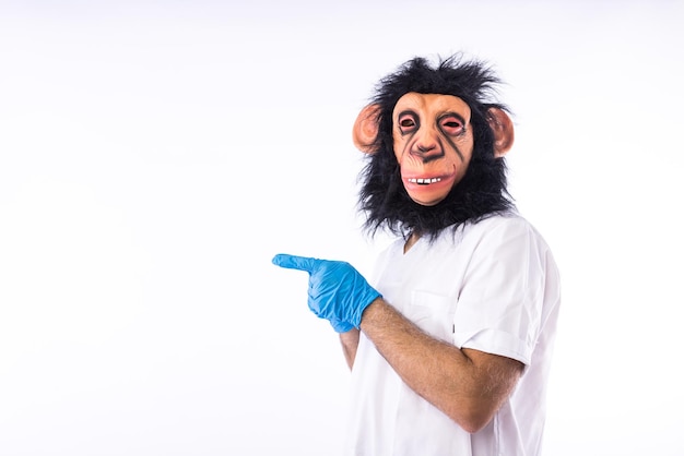 Person dressed in overalls with a mask wearing a medical nurse outfit pointing a finger to the side on white background Monkeypox pandemic virus epidemic Nigeria and smallpox concept