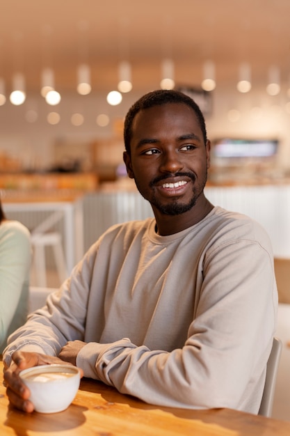 Person drinking coffee in spacious cafeteria