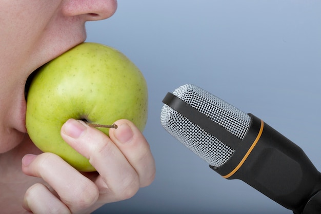 Photo person eating an apple close to microphone for asmr