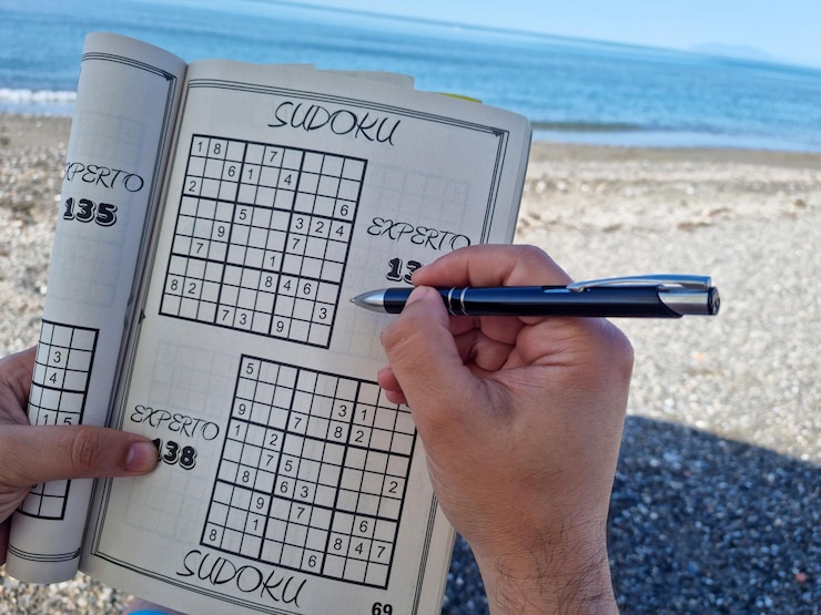Photo person enjoying a day at the beach doing sudoku