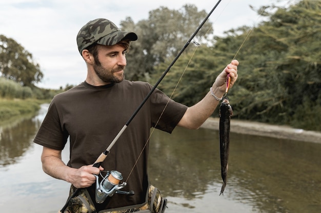 Foto persona che pesca un pesce con una canna