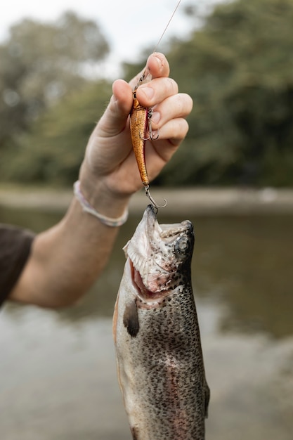 Photo person fishing a fish with a rod