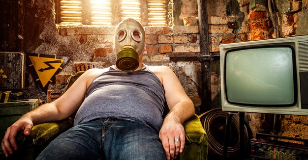 person in a gas mask sits on an armchair