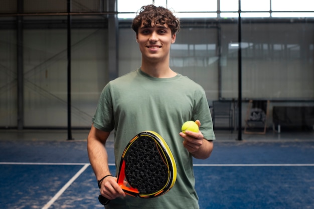 Person getting ready to play paddle tennis inside